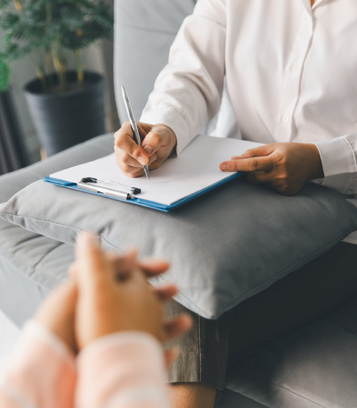 Consultation avec une psychologue clinicienne Psychologue clinicienne prenant des notes lors d’un entretien thérapeutique